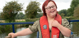Young lady with Down Syndrome steering a canal boat