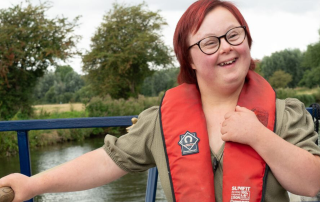 Young lady with Down Syndrome steering a canal boat