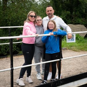 a family standing smiling on a bridge across a canal